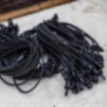 Spannfix schwarz - 30 kg pro Stück belastbar, VPE 20 Stück Draufsicht mehrerer schwarzer Spannfixe mit Haken, lose nebeneinander auf hellem Untergrund abgelegt