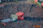 Frontlit PVC - individuell bdruckte B1 Werbeplane für Festivals FOH-Turm auf Festivalwiese, vollflächig verkleidet mit rot-orange bedrucktem Frontlit PVC Banner mit weißem Schriftzug