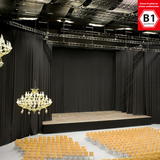 Schwarzer Moltonstoff als Bühnenvorhang auf einer Bühne, davor Sitzplätze und Chandelier-Beleuchtung