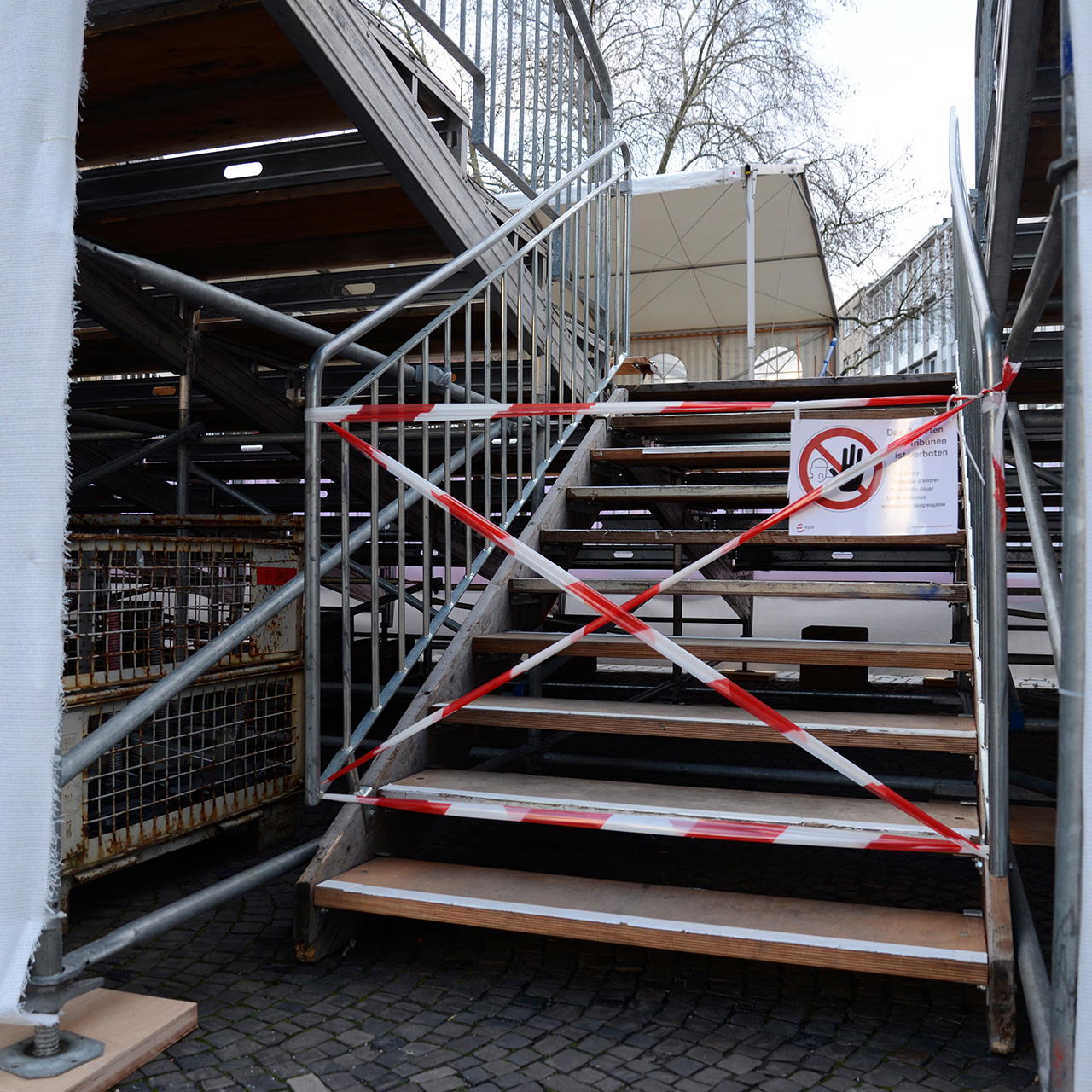Mit rot-weißem Absperrband und Verbotsschild gesperrte Aufgangstreppe in einem Veranstaltungsbereich