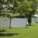 Gewebeplane günstig weiß - reißfester Sicht- und Windschutz für Events Bauzaunelemente mit weißer Gewebeplane als Sichtschutz auf einer Wiese, aufgestellt vor Eventzelt unter Bäumen