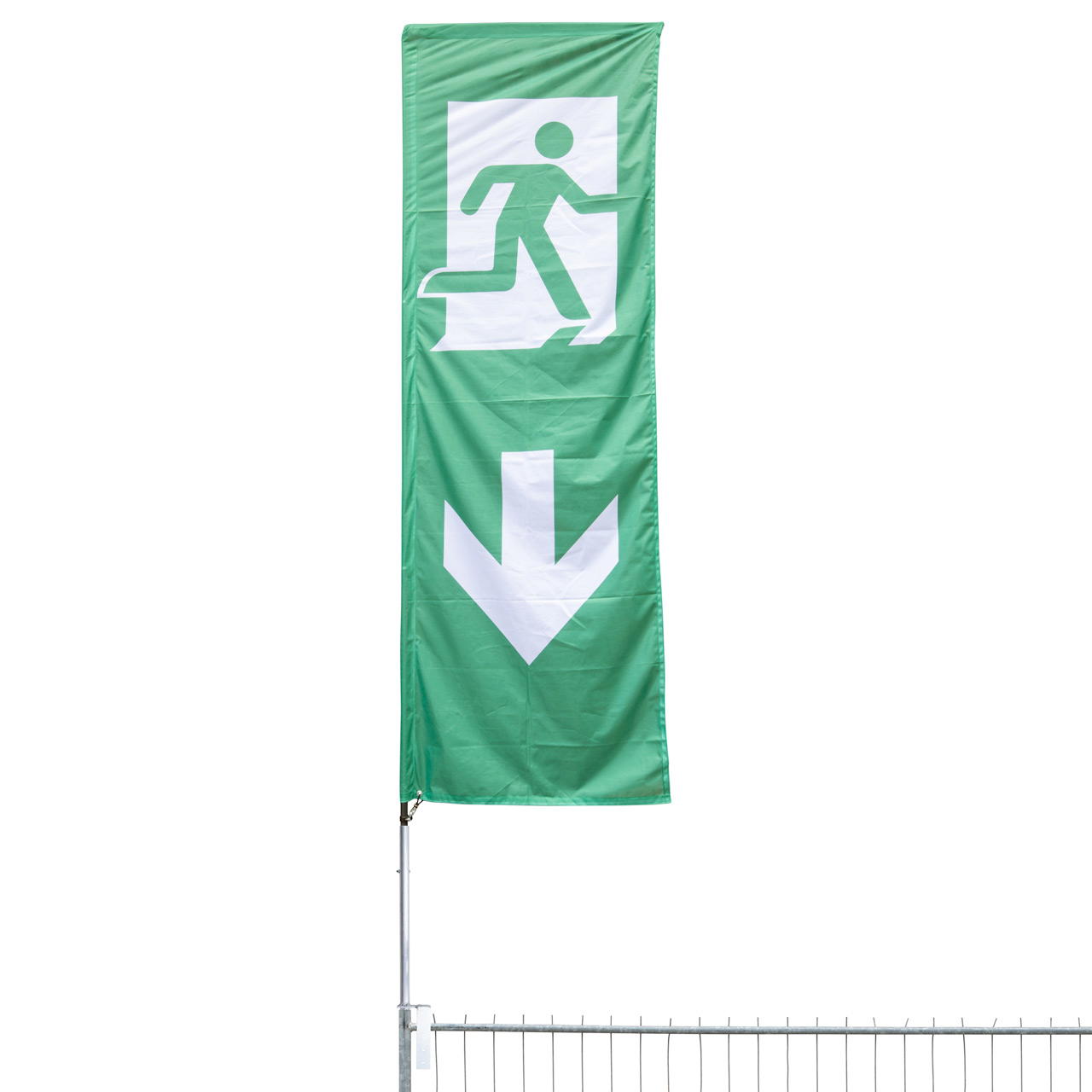 Freigestellte grüne Fahne mit Notausgangs-Piktogramm und Pfeil nach unten am oberen Segment eines Bauzauns montiert