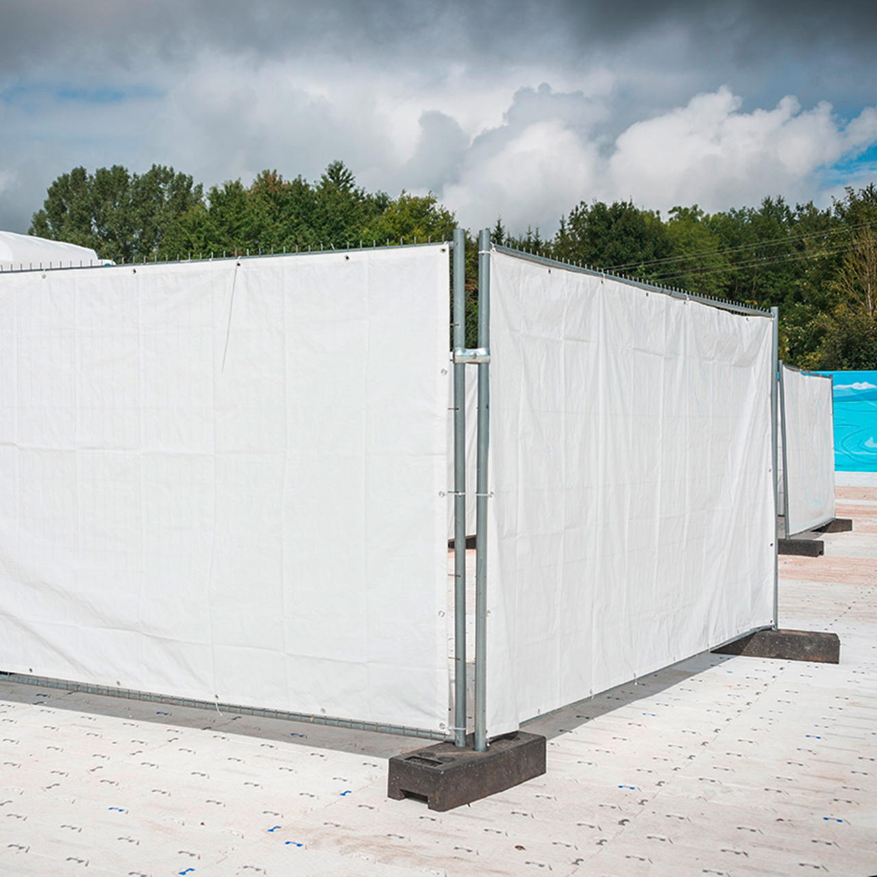 Ecke aus zwei Bauzaunelementen mit weißen Gewebeplanen als Sichtschutz für Festival, Events und Baustellen