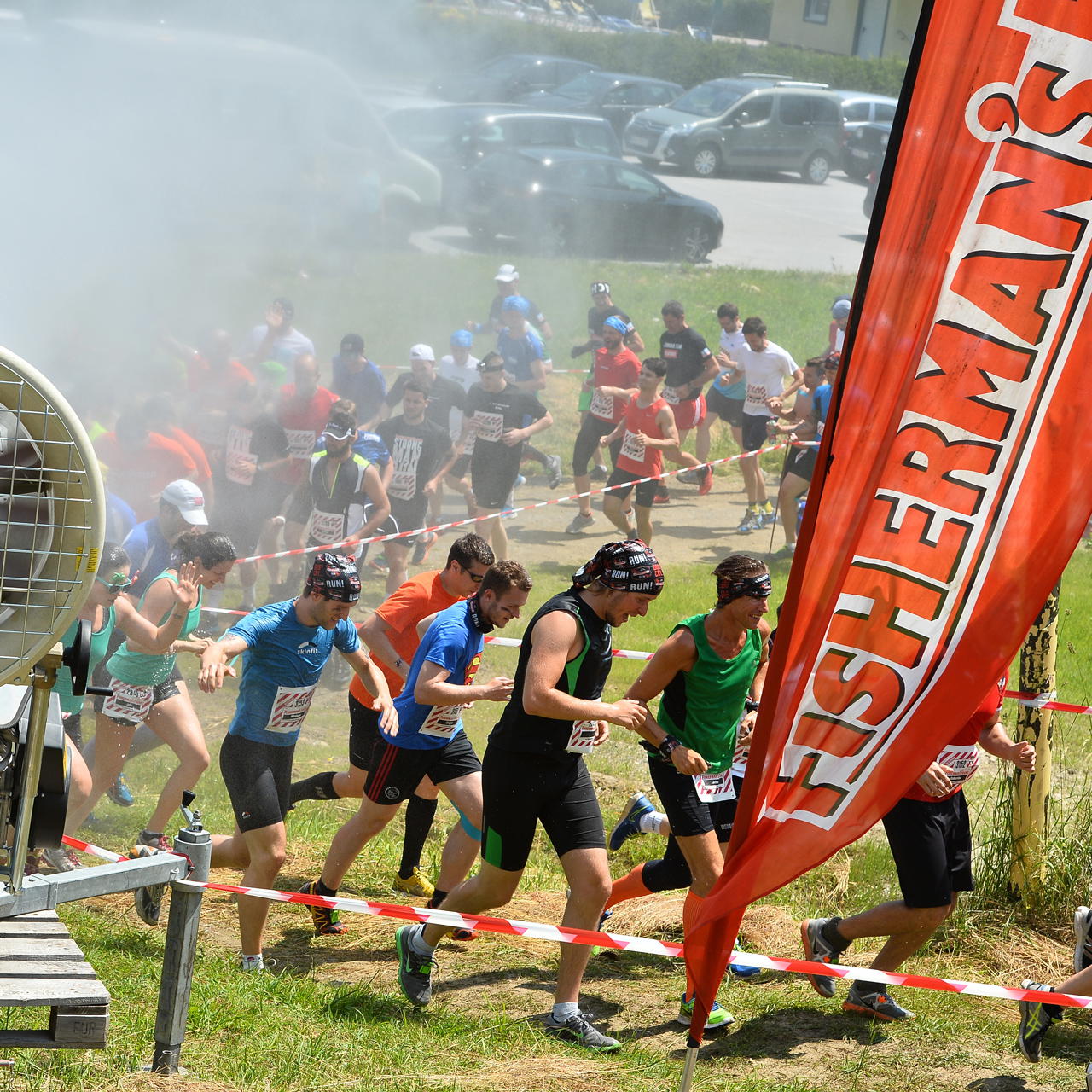 Teilnehmer eines Sportevents laufen entlang eines mit rot-weißem Trassierband markierten Streckenabschnitts