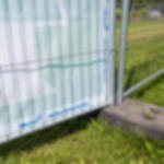 Notausgangsbanner rechts - Beschilderung für Outdoor Veranstaltungen Unterer Bereich der Rückseite eines Notausgangsbanners mit Aufdruck „Notausgang rechts“ befestigt am Bauzaun