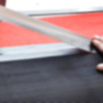 Gewebeklebeband GT 571 - anwendbar auf verschiedenen Flächen Hand bringt silbernes Gewebeklebeband zur Stoßverklebung von Feinriefenmatte und rotem Teppich an