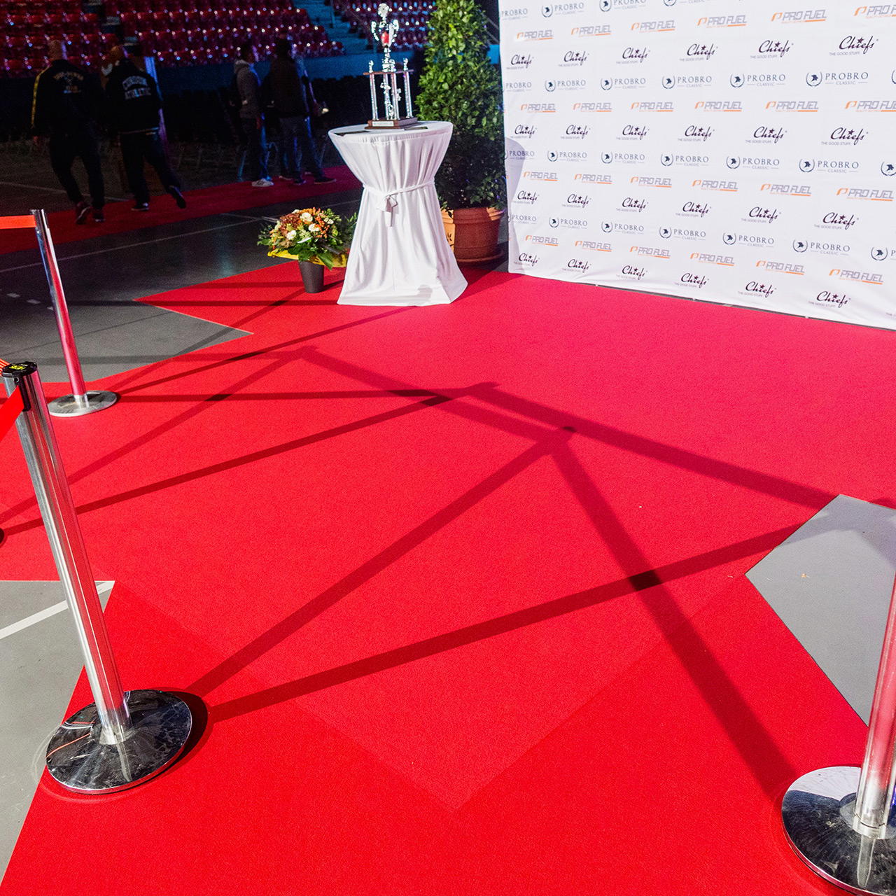 Roter Flachfilz als Eventteppich in der Photo Call Area eines Events verlegt, mit Absperrständern und Sponsorenwand 
