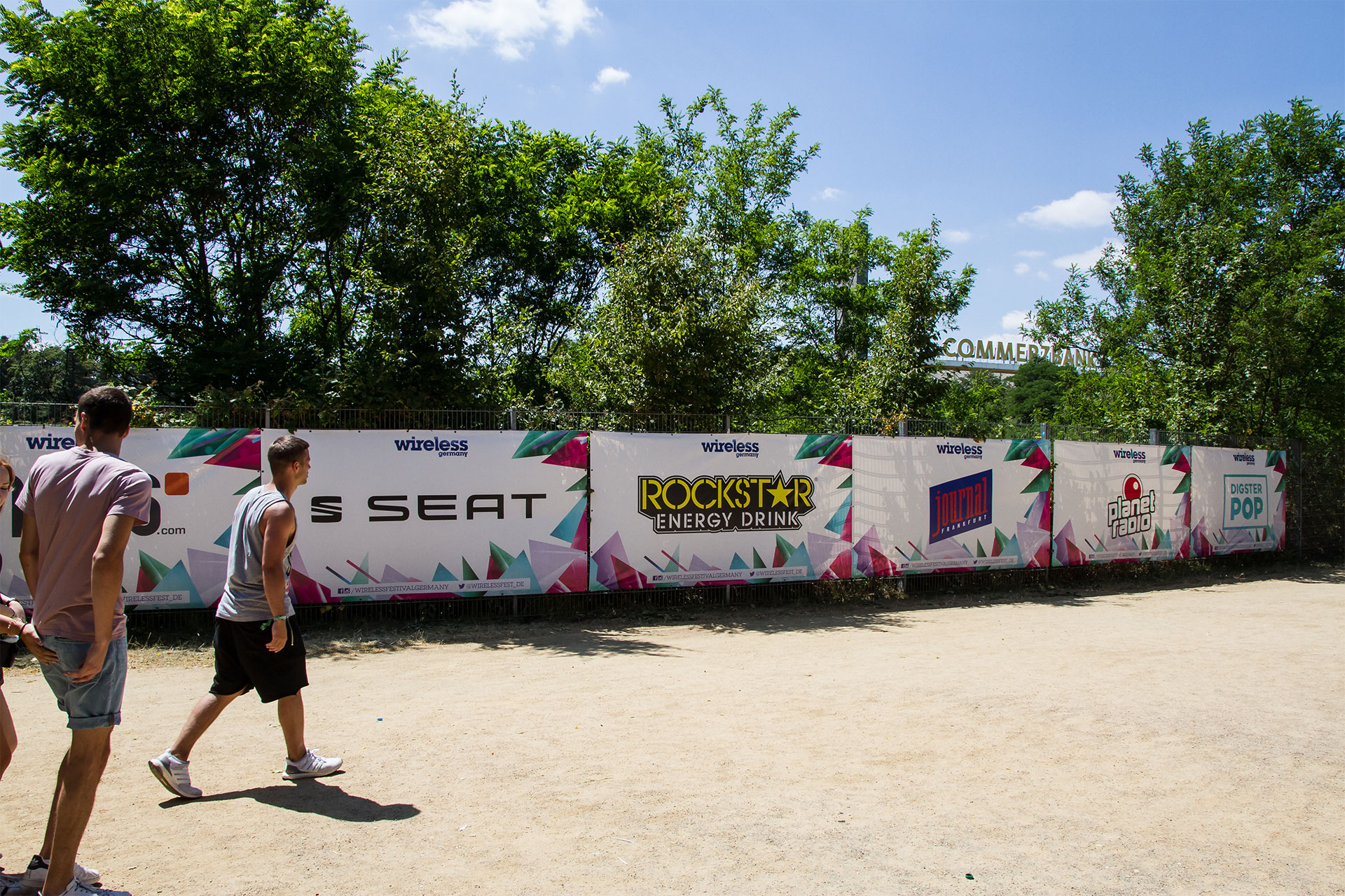 PVC Bauzaunbanner bedruckt mit weißem Hintergrund, mehrfarbigem Grafikdesign und Sponsorenlogos auf Festival