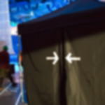 Gewebeklebeband GT 571 - zum Markieren von Wegen bei Veranstaltungen Zwei zueinander zeigende Pfeile aus weißem Gewebeband markieren den Eingang eines schwarzen Stoffpavilions