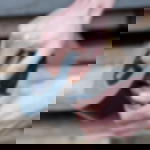 Gewebeklebeband schwarz - sauberer Handabriss mit geraden Kanten Eine Hand hält eine Rolle schwarzes Gewebeklebeband GT 571, die andere Hand reißt ein Stück ab