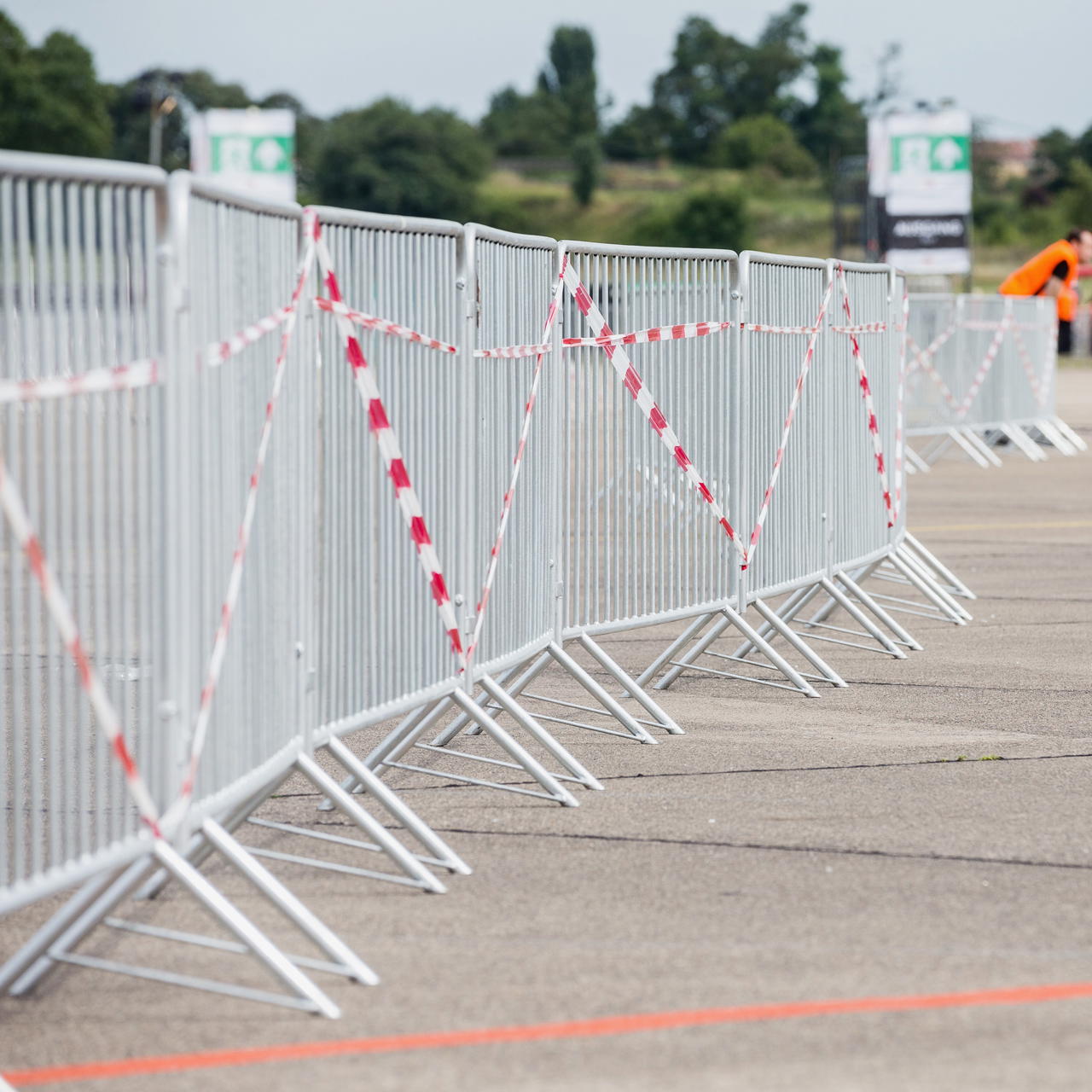 Rot-weißes Absperrband an mobilen Absperrgittern zur Markierung einer temporären Sperrzone bei einer Veranstaltung 