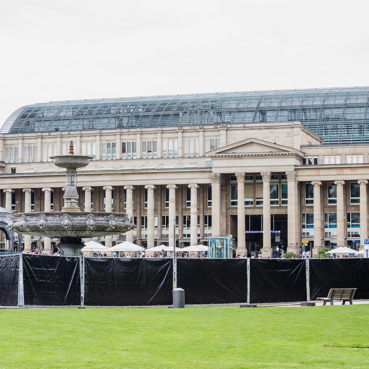 Schwarze Sichtschutzplanen an Bauzäunen vor dem historischem Königsbau am Stuttgarter Schlossplatz mit Brunnen