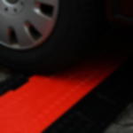 CableGuard Red Line 4-Channel, 55mm Ø, heavy-duty Cable Ramp Red Line 4-Channel application under vehicle wheel (Article No. 2011062)