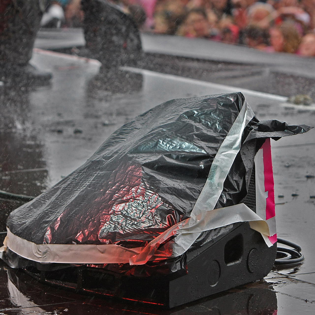 Gewebeklebeband zur Fixierung einer Abdeckplane über einem Bühnenmonitor bei Regenwetter auf einer Bühne