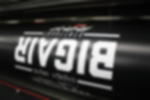 Frontlit PVC - fotorealistisch nach individuellen Vorgaben bedruckt Schwarze Frontlit PVC Plane mit weißem Schriftzug während des Digitaldruck-Vorgangs auf der Druckmaschine