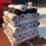 Gummiläufer GRIP als Rolle mit 100 cm Breite, 10 m Länge, 3 mm Stärke Palette mit gestapelten Rollen Gummimatten, teils unverpackt, auf einem Festivalgelände beim Bühnenaufbau