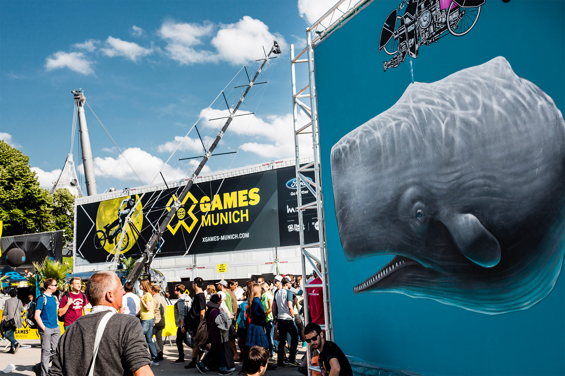 Fotorealistisch bedruckte PVC Banner mit Walmotiv und Eventlogo an Traversenkonstruktionen auf Event mit Besuchern