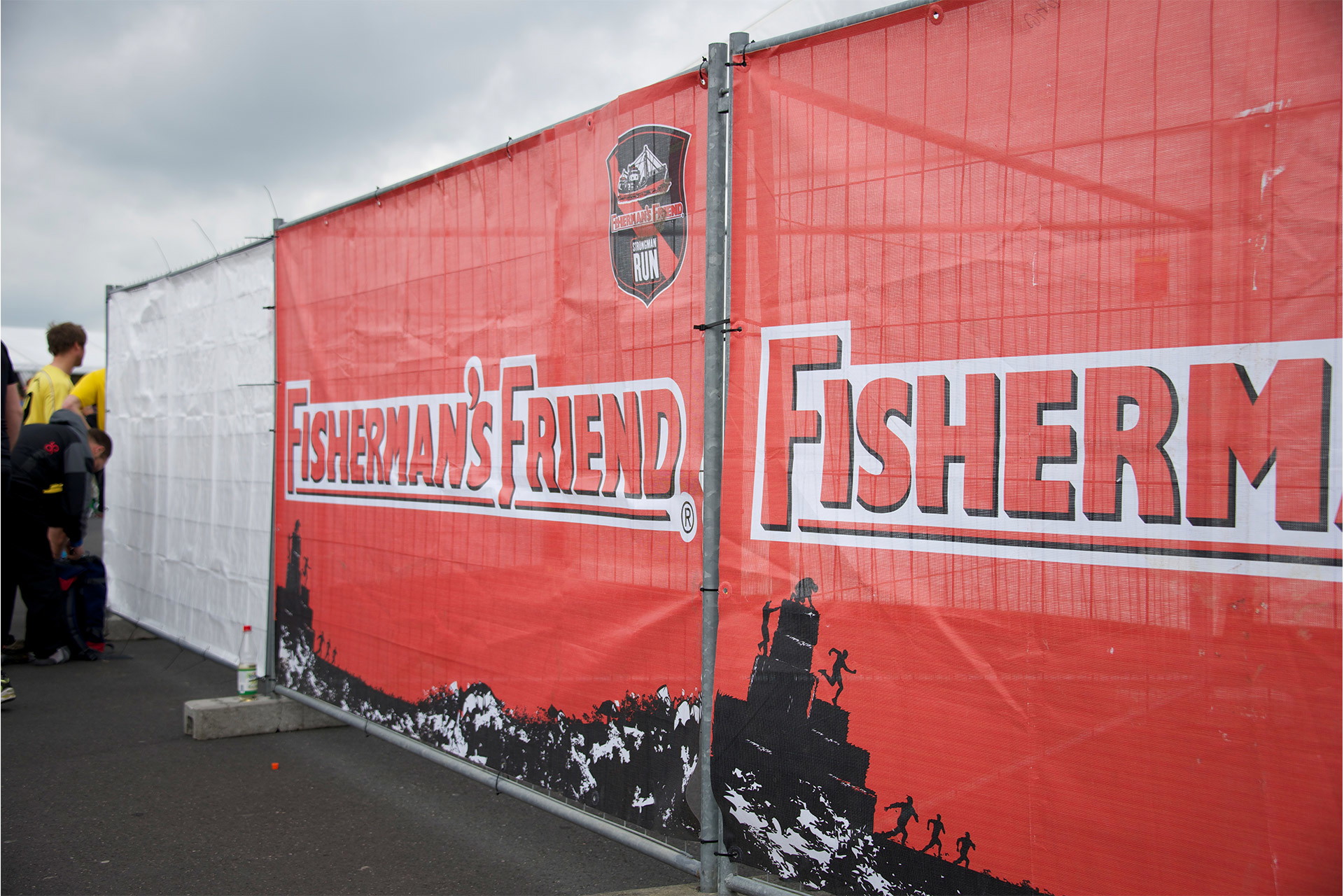 Geöstes Netzvinylbanner mit Fisherman’s Friend Sponsorenbranding als Bauzaunbanner bei Outdoor-Event