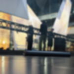 Bühnenboden für Events und Messen - robust und einfach zu verlegen Schräg liegende Rolle eines schwarzen Tanzbodens beim Eventaufbau auf einer Bühne mit Crew