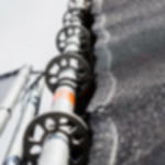 Spannfix schwarz - professionelles Spannen von Planen und Textilien Nahaufnahme der Befestigung eines geösten Banner-Netzgewebes mit Spannfixen an einem Gerüstgestänge bei einem Event