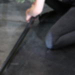 PVC Band GT 802 - extrem elastisches Klebeband für Veranstaltungen Eine kniende Person verklebt schwarzes mattes PVC-Band als Kantenband an einer Bühnenkante