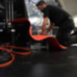 Messeteppich Rips B1 - 1 m x 50 m Läufer für Veranstaltungen Arbeiter verlegt während der Vorbereitungen für ein Event einen roten Rips-Messeteppich auf den Stufen einer Bühne