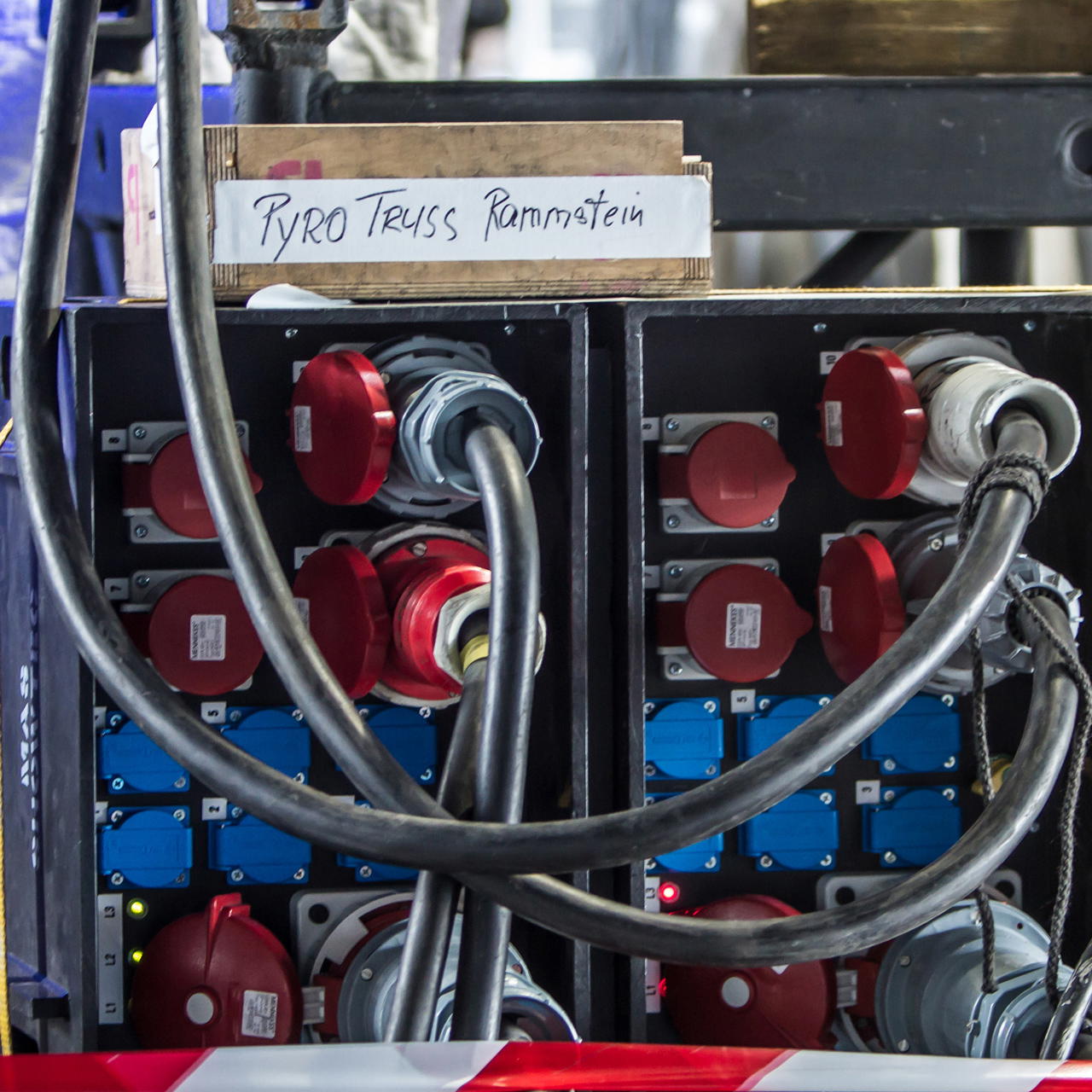 Abriss von weißem, beschriftetem Gewebeklebeband auf Holzbox, platziert auf Stromverteilerschrank im Bühnenbereich