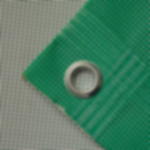 Notausgangsbanner Leitsystem - Mesh Banner Netzvinyl für Bauzaun Detailaufnahme der Ecke eines grünen Mesh-Banners mit PVC Beschichtung, randverstärkt und mit Öse zur Befestigung