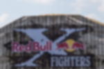 Frontlit PVC - als Sponsoren- und Werbebanner für Sportevents Frontlit PVC Plane bedruckt in Holz-Optik mit Red Bull X-Fighters Logo, montiert auf Holzrahmen auf einem Sportevent