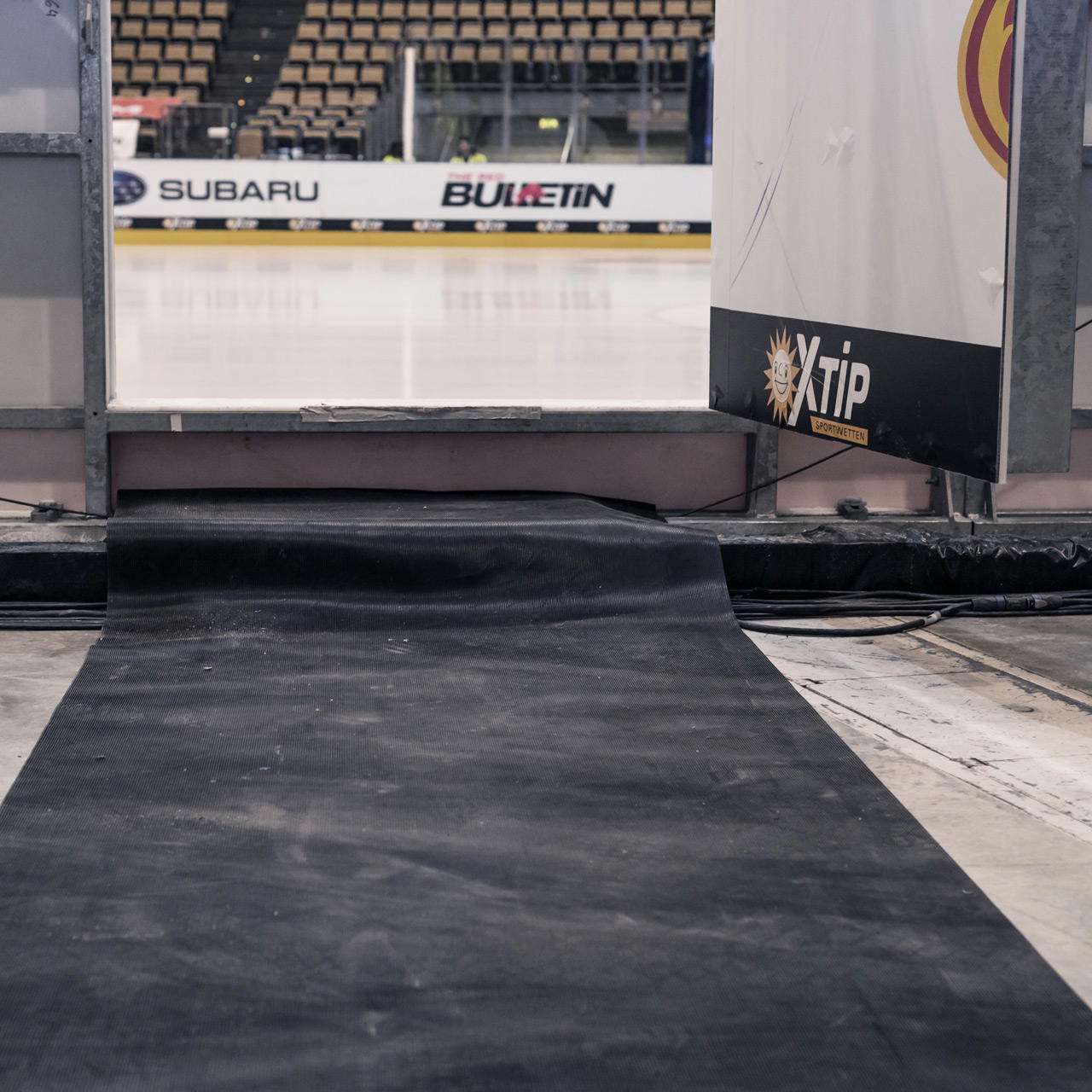 Gummiläufer verlegt in einer Eishalle als sicherer, strapazierfähiger Zugangsschutz vom Hallenboden zur Eisfläche