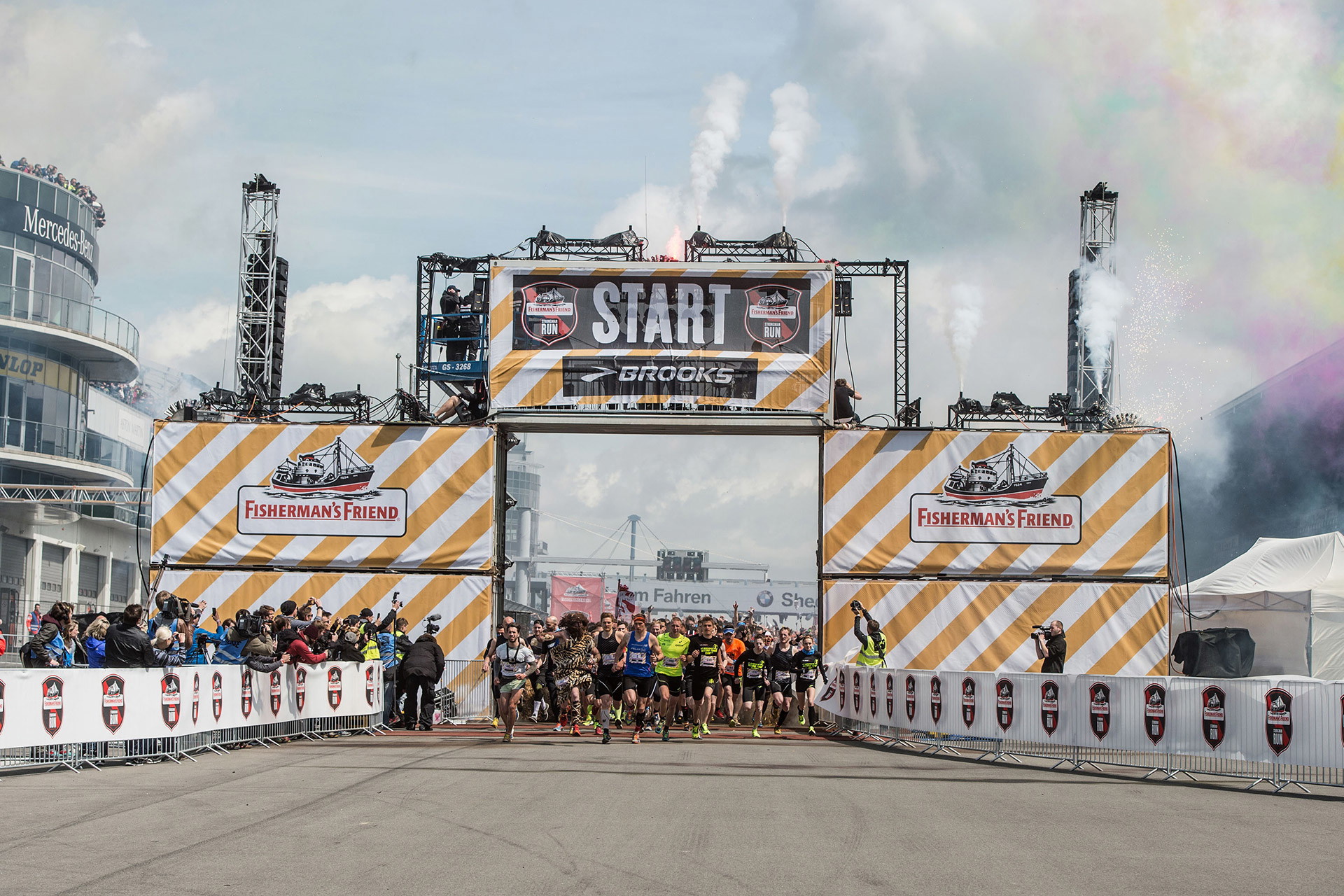 Startbereich eines Laufsportevents mit bedruckten Meshbannern als Großflächenwerbung in Gelb-Weiß am Startbogen