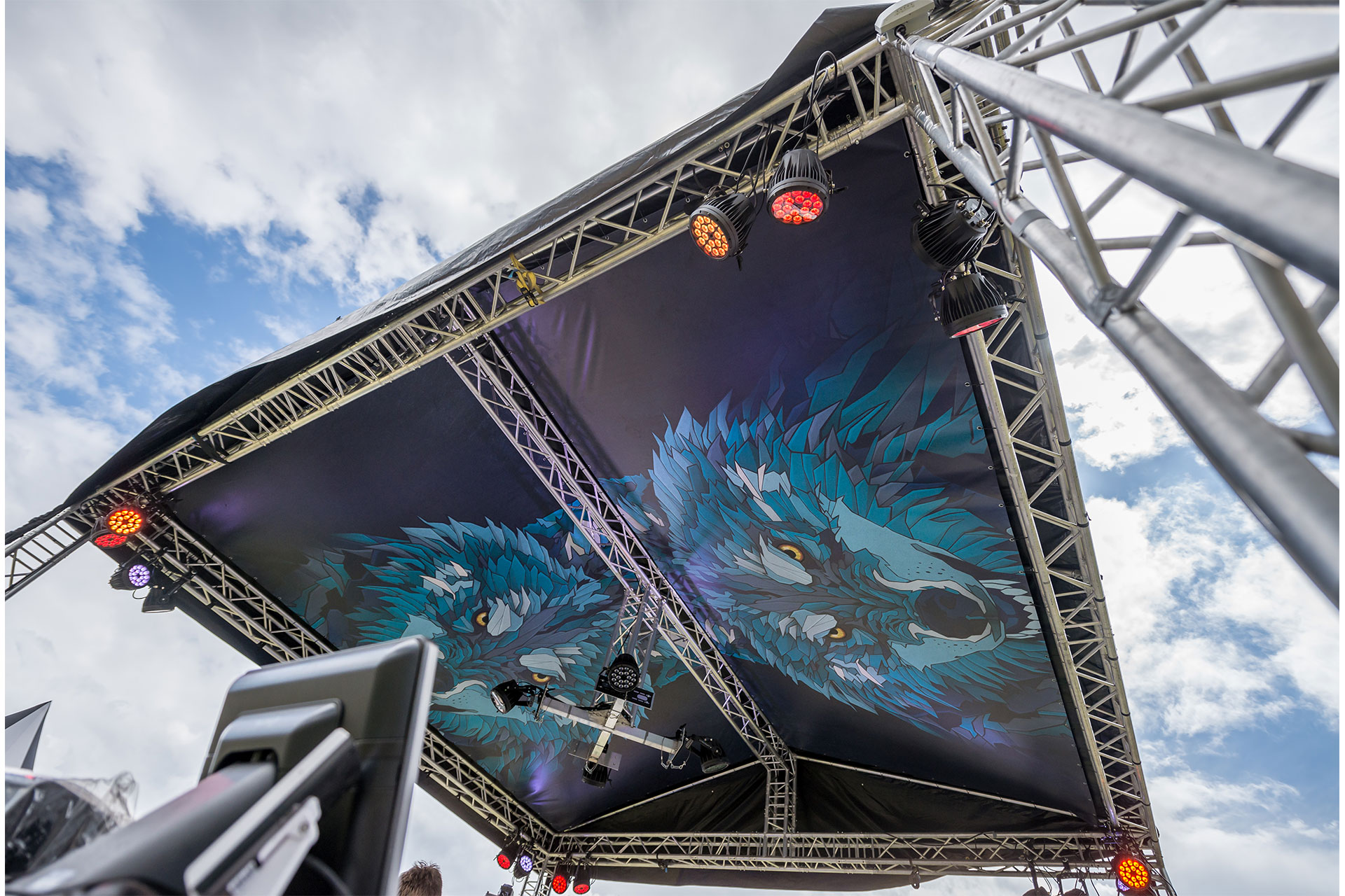 Mit blauem Wolfsmotiv auf schwarzem Grund bedruckte PVC Plane in Traversendachkonstruktion gespannt, auf einem Festival