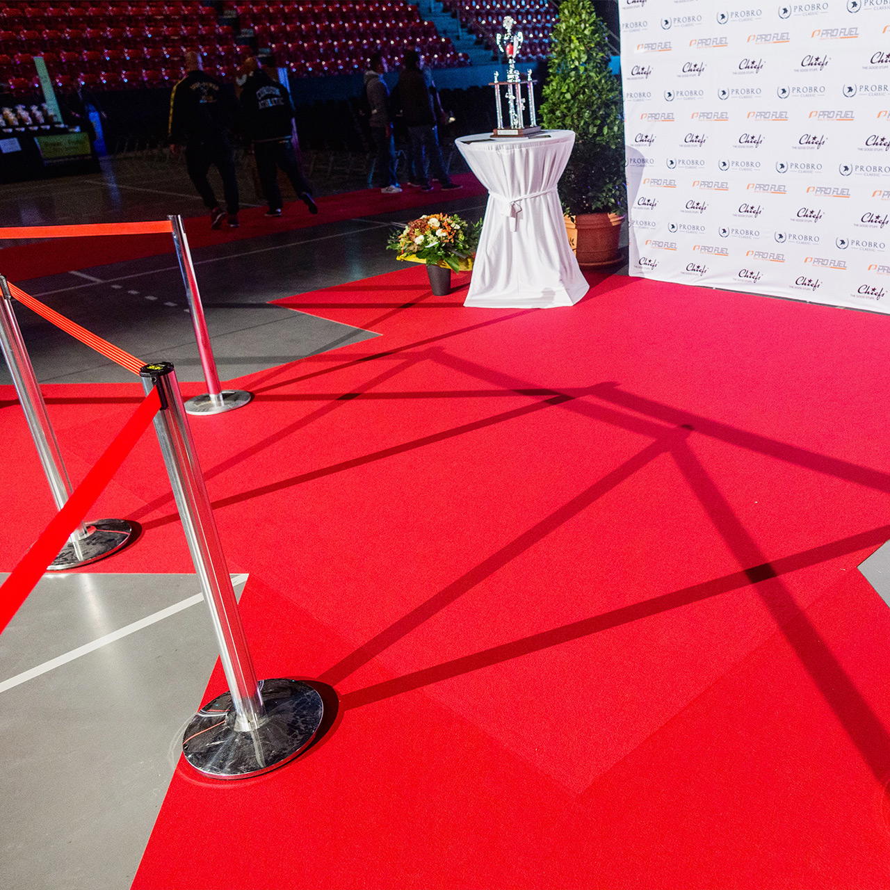 Roter Flachfilz als Eventteppich in der Photo Call Area eines Events verlegt, mit Absperrständern und Sponsorenwand 